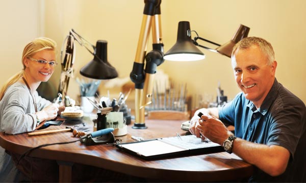 An image of people at a desk appraising jewelry items.